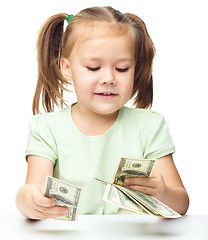 Image showing Little girl is counting dollars