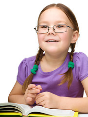 Image showing Little girl is reading a book