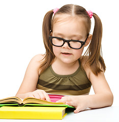 Image showing Little girl is reading a book