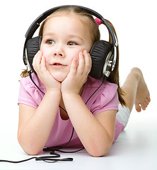 Image showing Cute little girl enjoying music using headphones