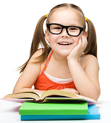 Image showing Little girl is reading a book