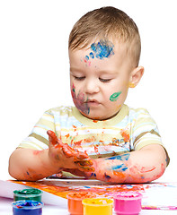 Image showing Little boy is playing with paints