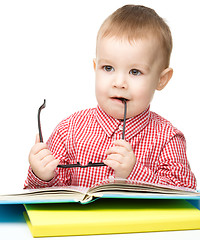 Image showing Little child play with book