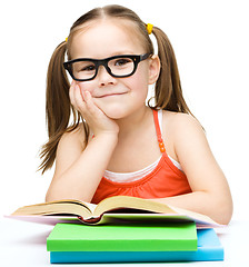 Image showing Little girl is reading a book