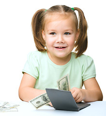 Image showing Little girl is counting dollars