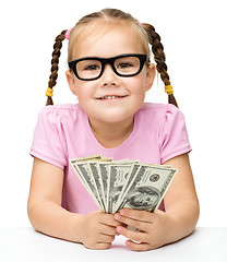 Image showing Little girl is counting dollars