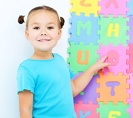 Image showing Little girl is pointing at letter O on alphabet