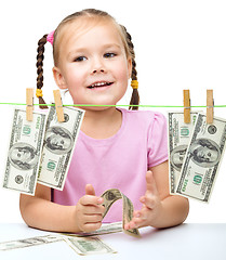 Image showing Cute little girl is playing with paper money