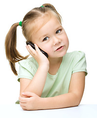 Image showing Cute little girl is talking on a cell phone