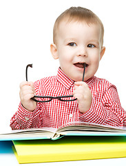 Image showing Little child play with book