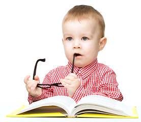 Image showing Little child play with book