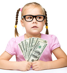 Image showing Little girl is counting dollars