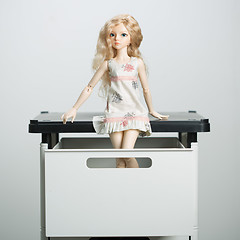 Image showing doll in a box on a light background. blurred rear plan