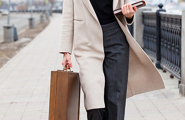 Image showing woman in a light coat, with a wooden case