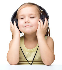 Image showing Little girl is enjoying music using headphones