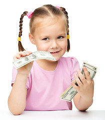 Image showing Little girl is counting dollars