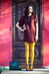 Image showing woman in a fashionable burgundy dress and orange pantyhose