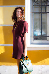 Image showing european middle-aged woman in a burgundy fashionable dress