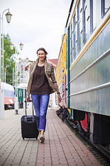 Image showing woman with luggage rushing on train