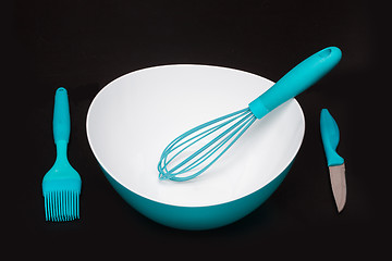 Image showing Green silicone pastry brush and soup plate isolated on black