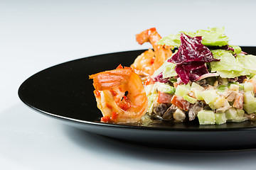 Image showing perfect dish with shrimps on a black plate. seafood