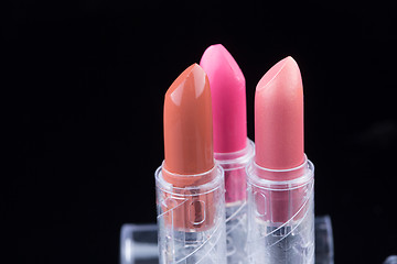 Image showing bright lipsticks on a black background