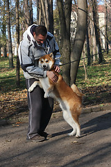 Image showing Man and joyful dog in public park