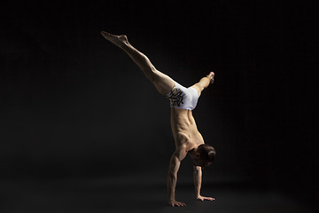 Image showing young man dancing over black