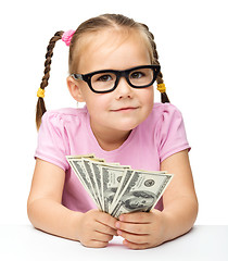 Image showing Little girl is counting dollars