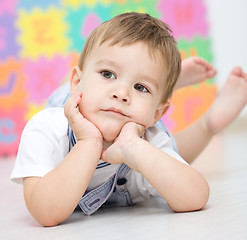 Image showing Little boy is laying on a floor