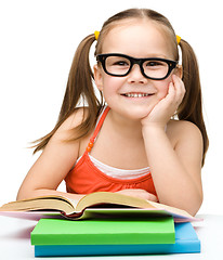 Image showing Little girl is reading a book