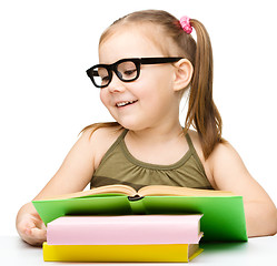 Image showing Little girl is reading a book