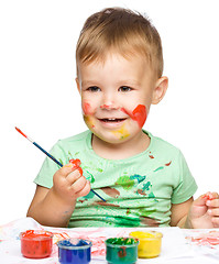 Image showing Little boy is playing with paints