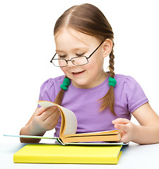 Image showing Little girl is reading a book