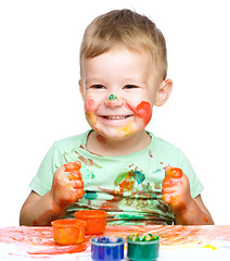 Image showing Little boy is playing with paints