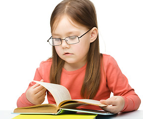 Image showing Little girl is reading a book