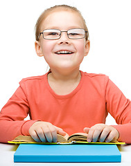 Image showing Little girl is reading a book