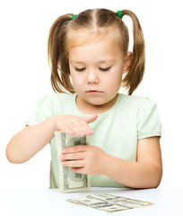 Image showing Little girl is counting dollars