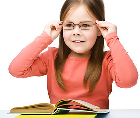 Image showing Little girl is reading a book