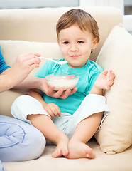 Image showing Cute little boy is fed using spoon