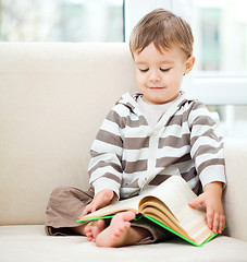 Image showing Little boy is reading book