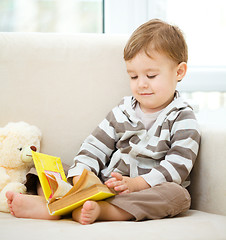 Image showing Little boy is reading book