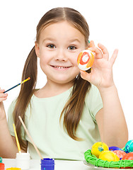 Image showing Little girl is painting eggs preparing for Easter