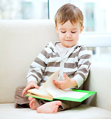 Image showing Little boy is reading book