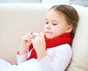 Image showing Ill little girl is reading thermometer