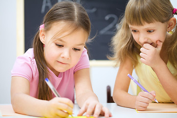 Image showing Little girls are writing using a pen