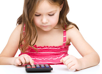 Image showing Little girl is using calculator