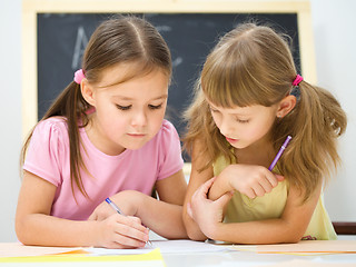 Image showing Little girls are writing using a pen