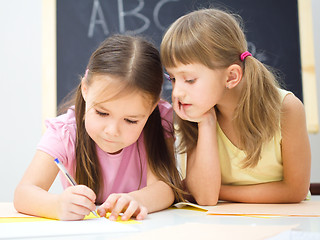 Image showing Little girls are writing using a pen