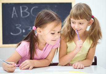 Image showing Little girls are writing using a pen